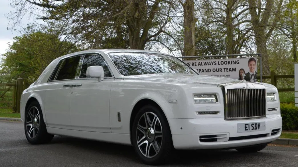 A selection of white Luxurious and modern vehicles all decorated with matching white ribbons on wedding duties in Stamford. Frot Left to right: Rolls-Royce Phantom, Rolls-Royce Gho