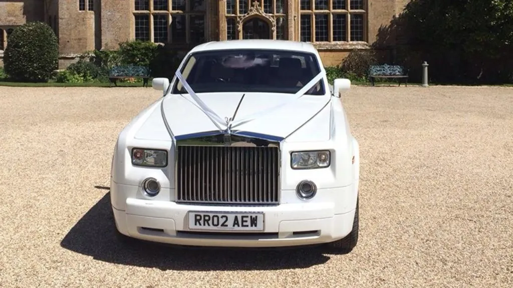 Front view of white Rolls-Royce Phantom with with ribbons